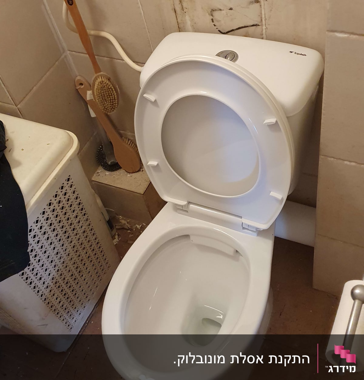 אסלה פתוחה עם צינור מים על הקיר